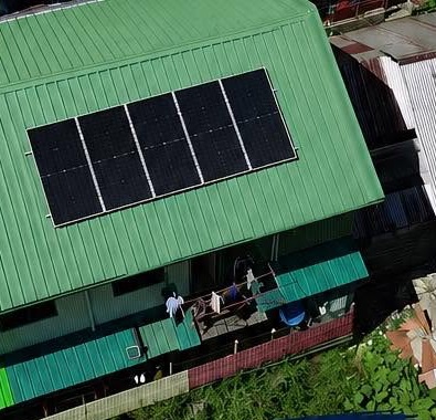 Aerial view of five solar panels on a green metal roof in Pag-antayan, Cantilan